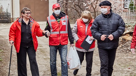 Du personnel de la Croix-Rouge assiste une femme.