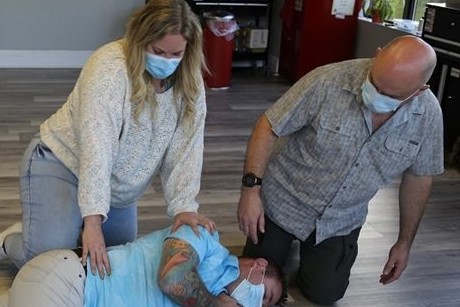 L'instructeur Larry Eisenhauer enseigne la position de récupération à sa collègue Erin Nauss, en utilisant le genou pour rouler une personne sur le côté (Kyle Mohler).