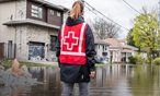 Des bénévoles de la Croix-Rouge pataugent dans une collectivité touchée par une inondation