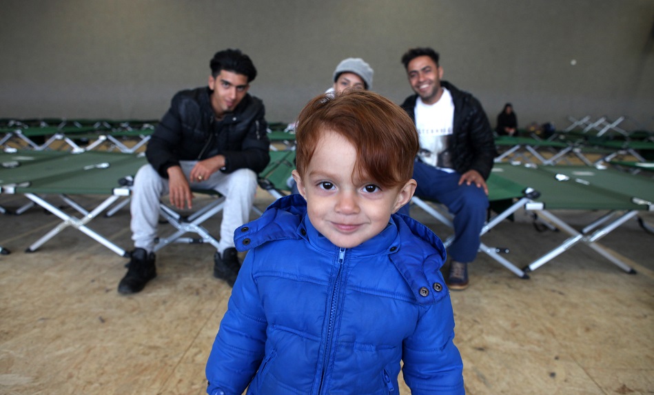 Un garçon et sa famille au centre d’accueil Feldkirchen, en Allemagne, géré par la Croix-Rouge allemande.
