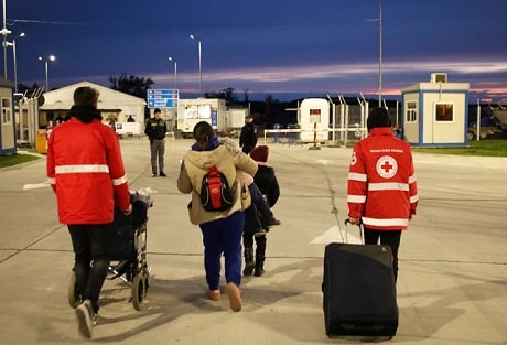 Des membres de la Croix-Rouge roumaine aident des réfugiés ukrainiens à la frontière
