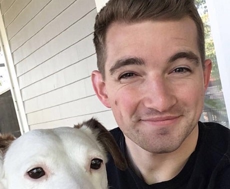Un homme souriant tenant un chien