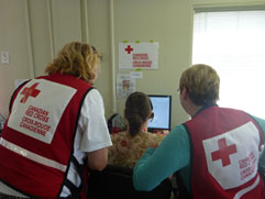 Une agente d’un centre d’appels de la Croix Rouge mène une entrevue téléphonique confidentielle avec un sinistré de l’Alberta.