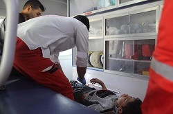 Deux ambulanciers paramédicaux aident un garçon blessé dans une ambulance