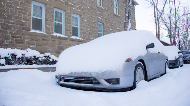 Une voiture est recouverte de neige.