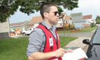 Oliver Whelan à l’extérieur tenant une planche à clip portant un gilet de la Croix-Rouge