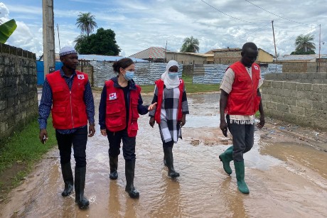 Sarah Parisio marche avec 3 collègues de la Croix-Rouge dans une rue inondée