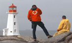 Un employé de la Croix-Rouge canadienne prend des photos d'un phare