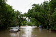 Une rue inondée en Alberta avec des voitures flottant sur l'eau