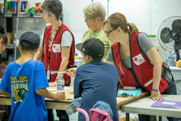 Des bénévoles guident les enfants évacués vers des jeux