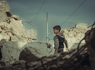 Un jeune garçon dans un tas de décombres