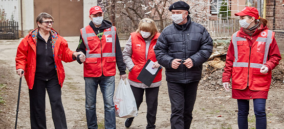 Du personnel de la Croix-Rouge assiste une femme.