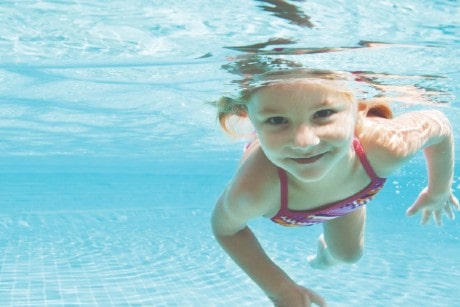 Petite fille nageant dans une piscine, sous la surface de l'eau
