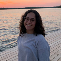 Portrait de Adi devant un lac et un coucher de soleil
