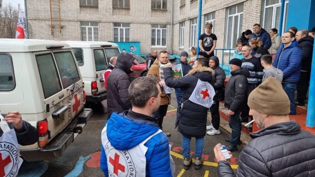 Des travailleurs du Comité international de la Croix-Rouge parlent avec des hommes.