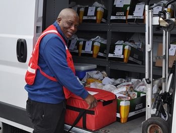 Un homme charge des fournitures dans une camionnette de la Croix-Rouge