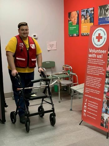 Julien Robichaud se tient debout avec une marchette dans un centre de prêt d'équipement médical.