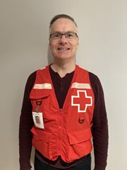 Une photo de Jacques Roy portant un gilet de la Croix-Rouge canadienne.