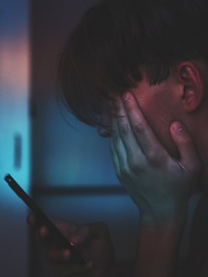 Un adolescent semble triste en regardant son téléphone portable